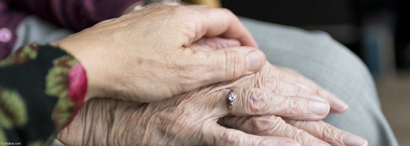Eine junge Hand hält eine alte Hand
