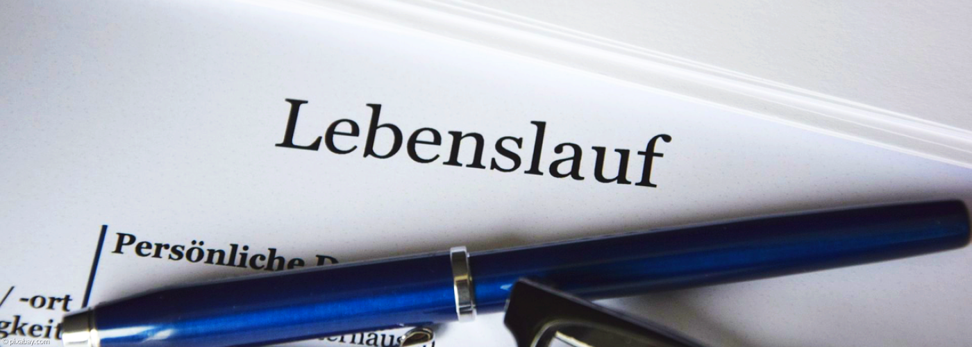 Symbolbild für Stellenausschreibungen: Ein Lebenslauf, auf dem ein blauer Kuli mit einer Lesebrille liegt