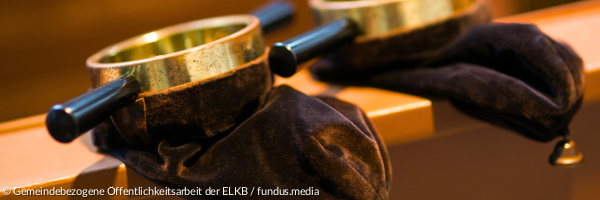 Zwei Klingelbeutel liegen auf einer Kirchenbank