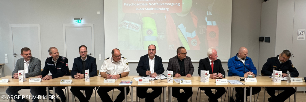 Die Arbeitsgemeinschaft Psychosoziale Notfallversorgung in Nürnberg, der dritte Bürgermeister und der Feuerwehrchef unterzeichnen Vereinbarung zur Zusammenarbeit mit Kirchen, Hilfsorganisationen und Polizei