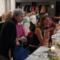 Frauen unterschiedlichen Alters unterhalten sich angeregt an einer festlich gedeckten Tafel.
