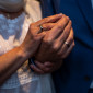 Ein älteres Ehepaar hält seine Hände mit Hochzeitsringen ins Bild.
