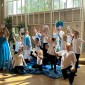 Kinder üben für ein Theaterstück und stellen mit blauen Tüchern die Wellen des Meeres dar